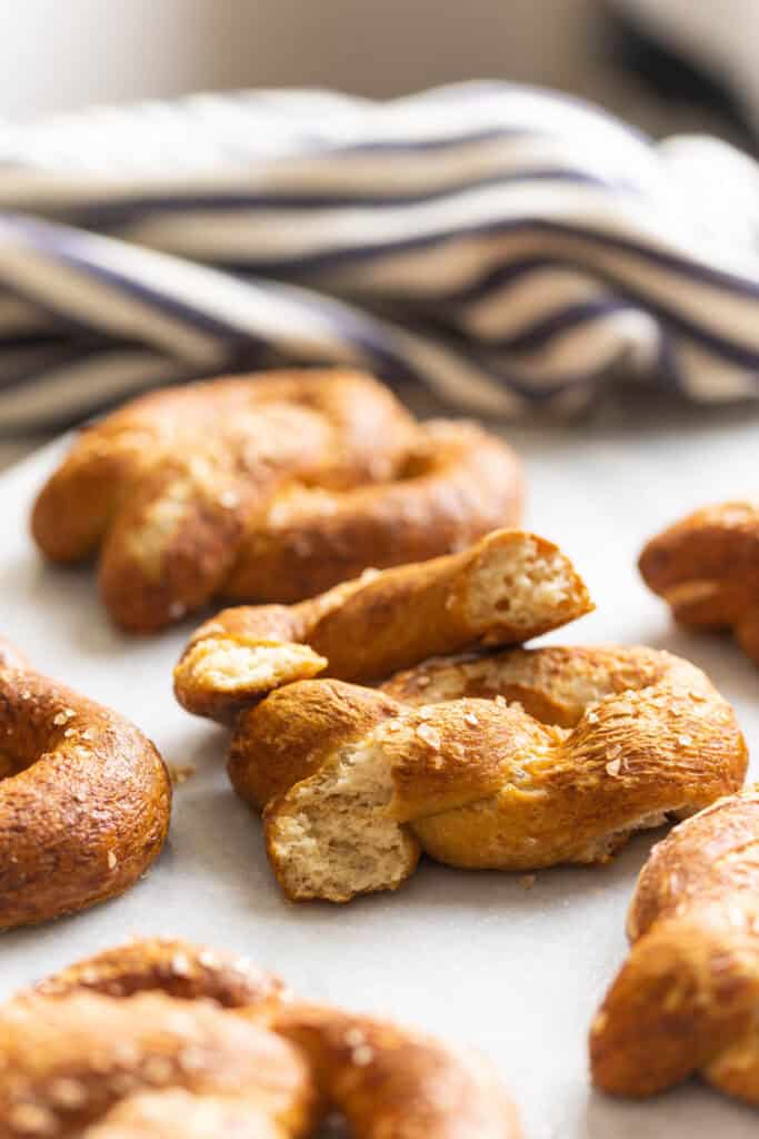 A homemade gluten free soft pretzel torn in half to show off the tender bread inside.