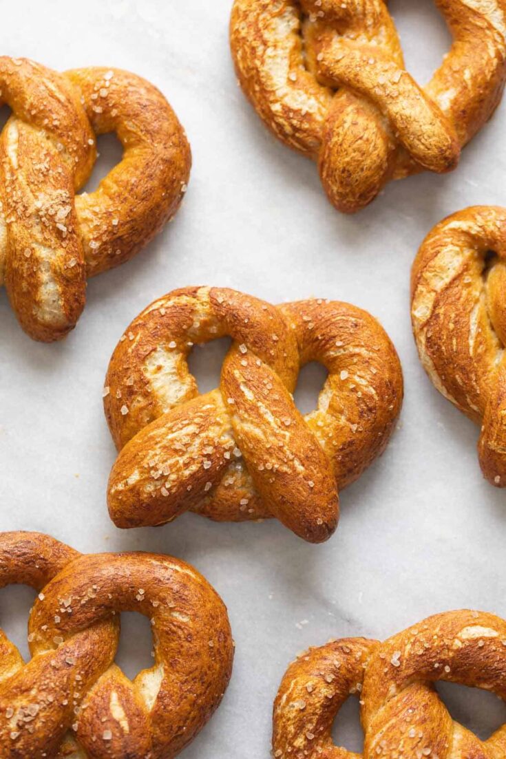 Homemade Gluten Free Soft Pretzels in rows with coarse sea salt sprinkled on top.