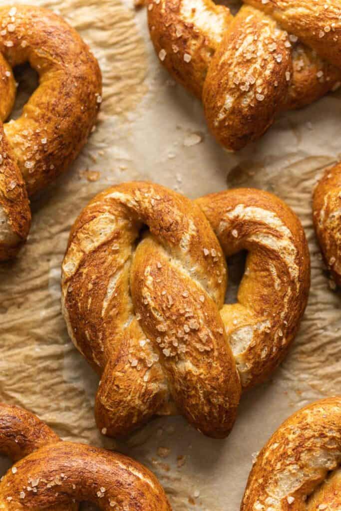 Homemade gluten free soft pretzels on a a parchment paper lined baking sheet.