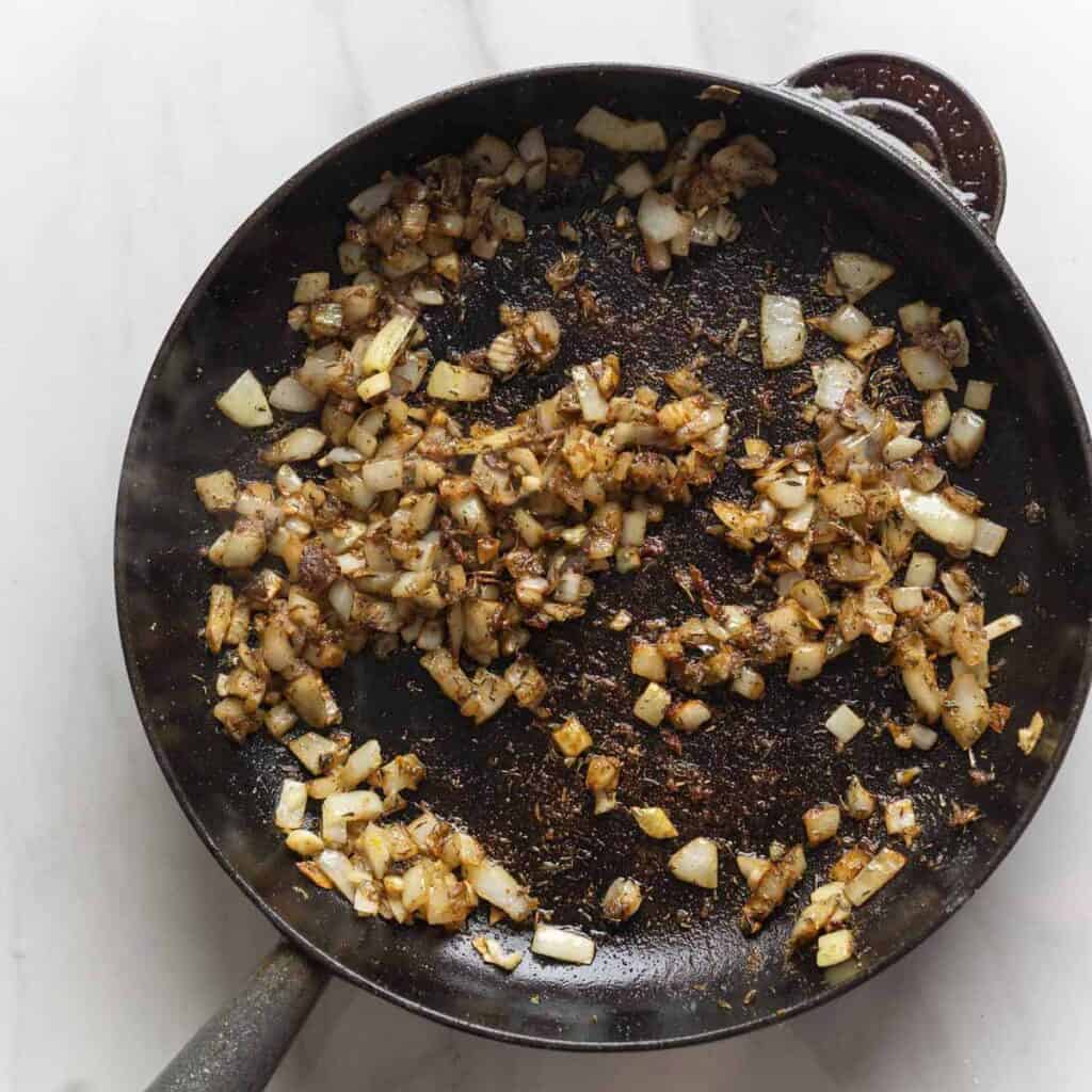 Chopped onions, garlic, lemon zest, chopped anchovies, dried thyme and  ground cumin, sautéed in a cast iron skillet.