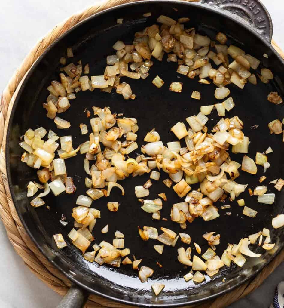 A large cast iron skillet full of sautéd, diced potatoes.