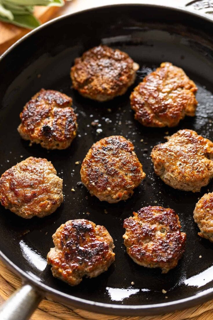 Nine Turkey Maple Breakfast Sausage Patties on a cast iron skillet.