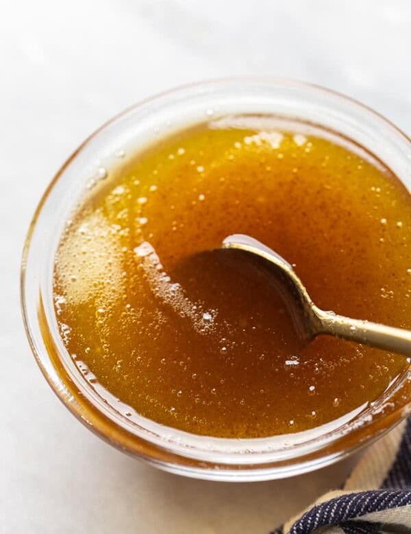 A spoonstirring and browned butter cooling in a small bowl.