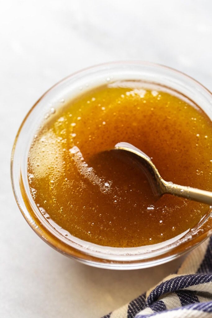 A spoonstirring and browned butter cooling in a small bowl.