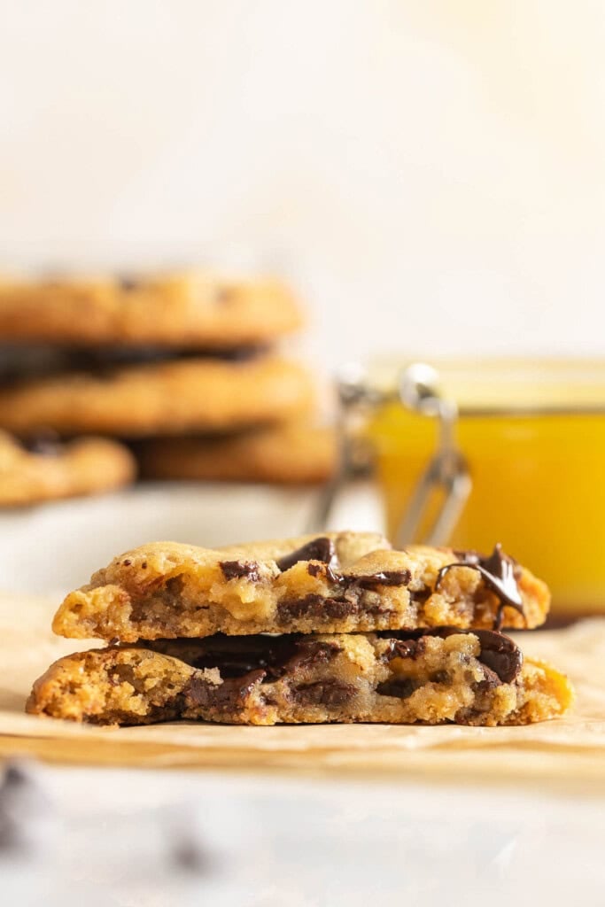 Two halves of a gluten free brown butter chocolate chip cookie stacked on top of each other.