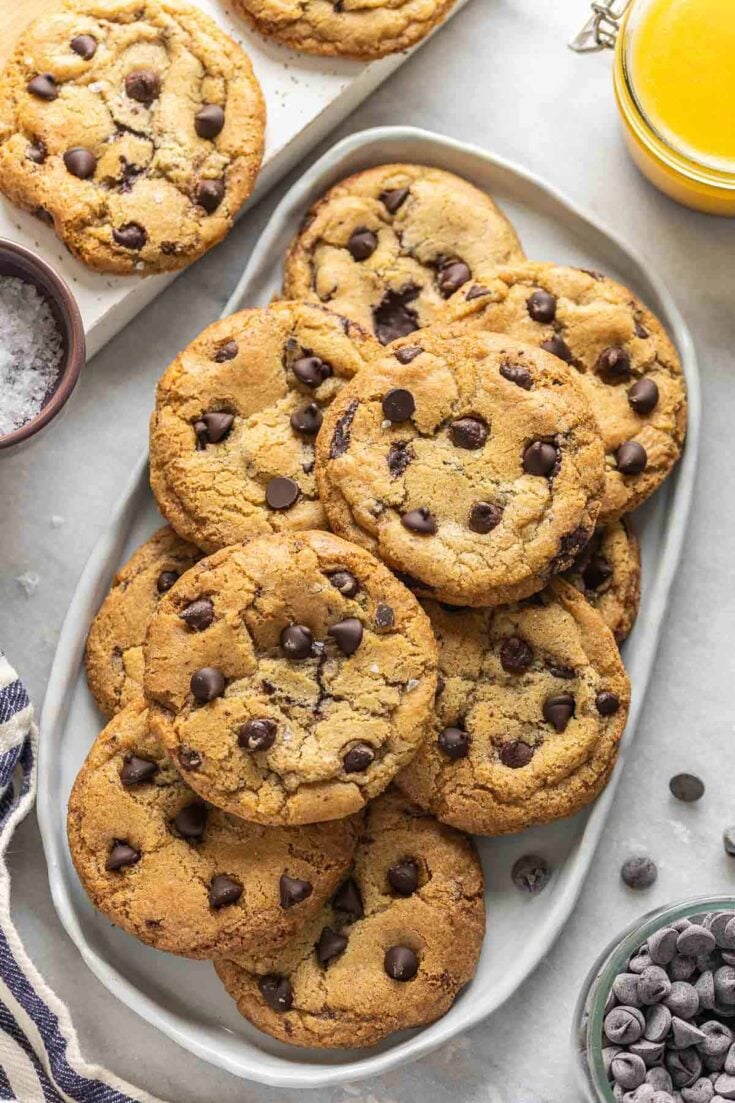 Gluten free brown butter chocolate chip cookies piled on a platter.
