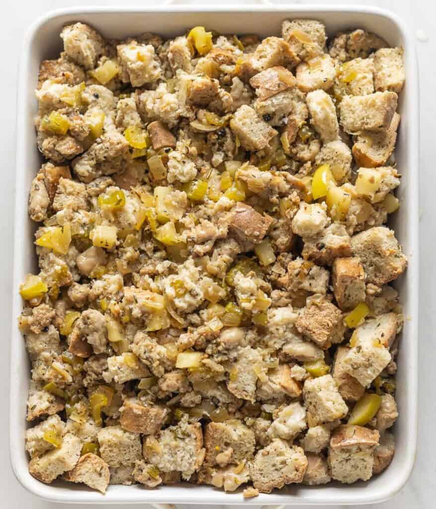 Unbaked, guten free sausage stuffing in a baking dish.