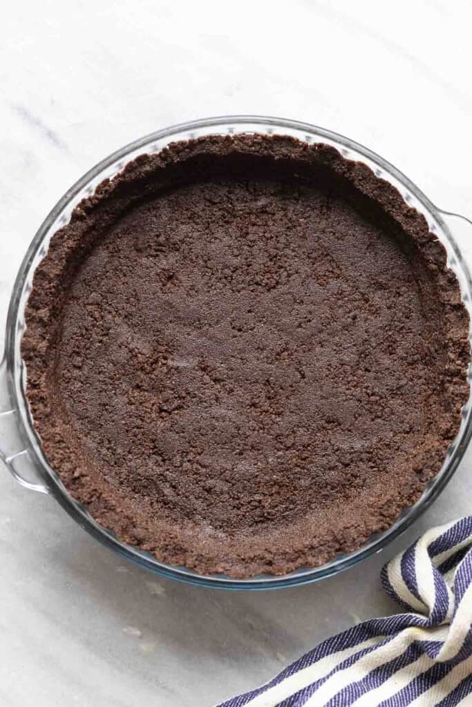 An unbaked gluten free oreo pie crust in a baking dish