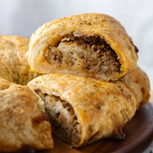 A Gluten free sausage bread slice sat on top of another slice.