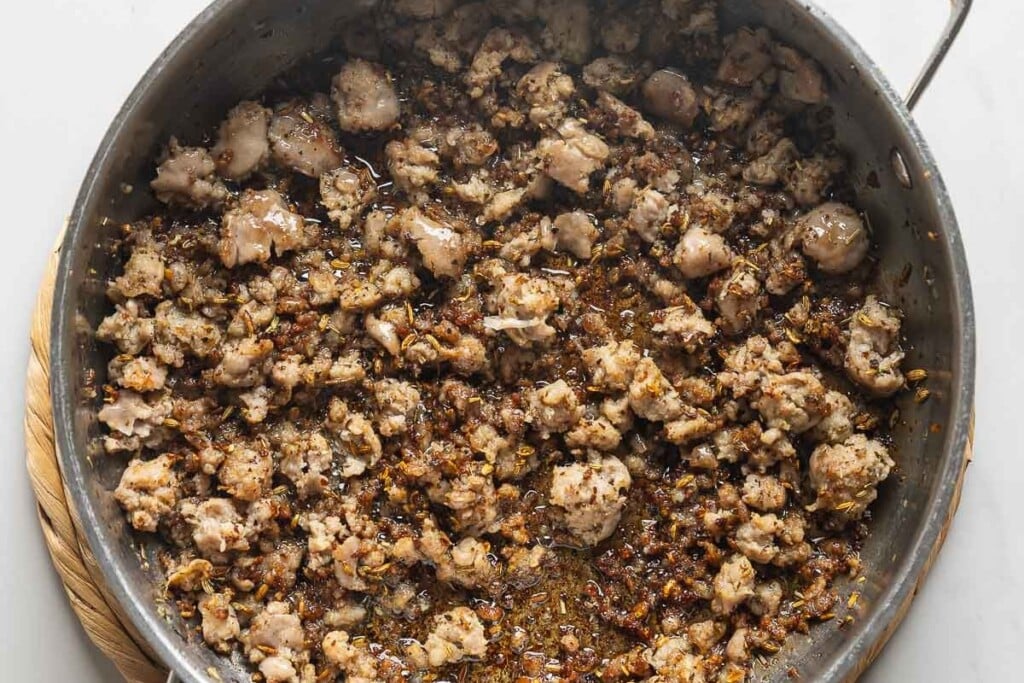 Cooked and crumbled Italian sausage in a large skillet.