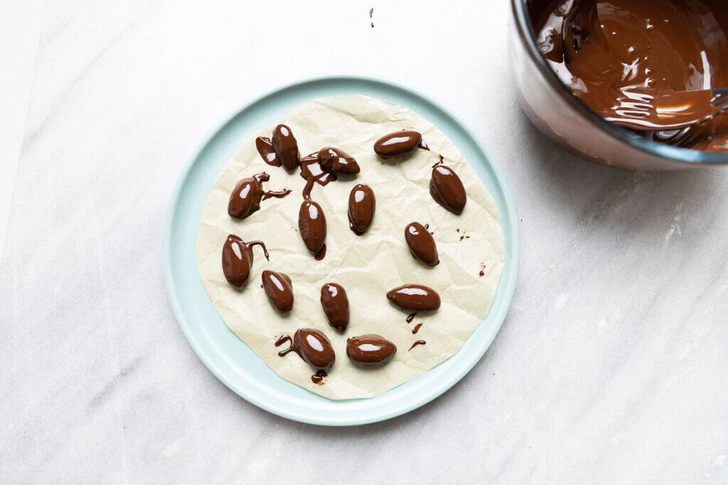 Chocolate covered almonds drying on a plate