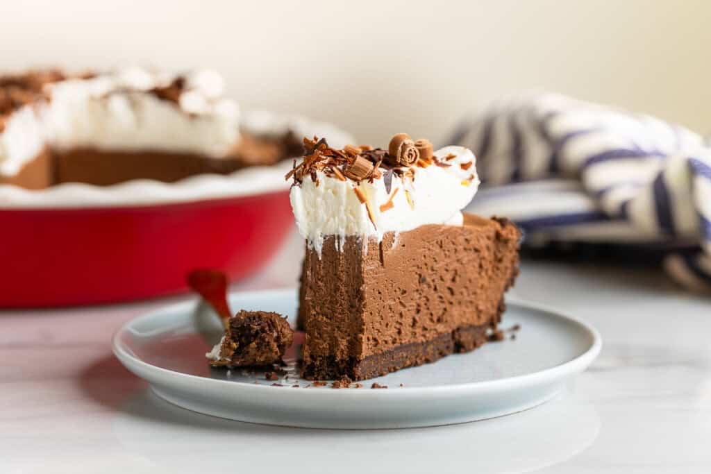 a slice of gluten free french silk pie on a plate with a bite taken out