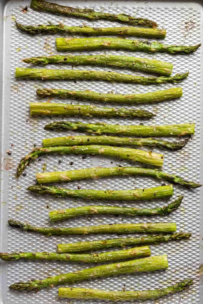 Oven Roasted Asparagus spread out on a baking sheet