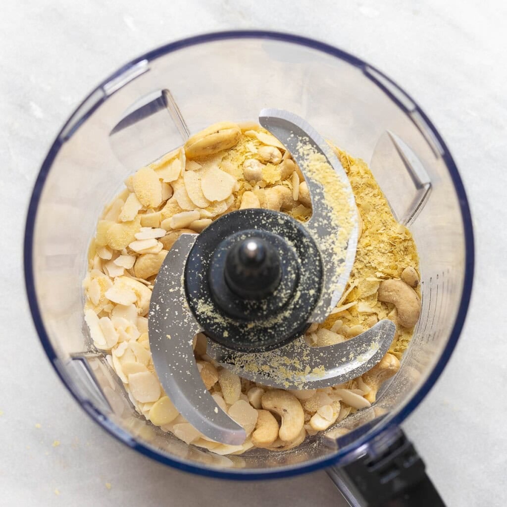 Raw cashews, almonds, nutritional yeast, salt, pepper and onion powder in a food processor with an S-blade attachment.