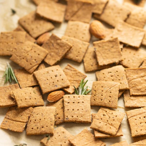 Homemade almond pulp crackers with scattered bits of rosemary, thyme and almonds.