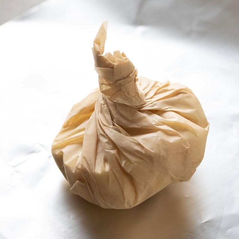 A head of garlic wrapped up in parchment paper