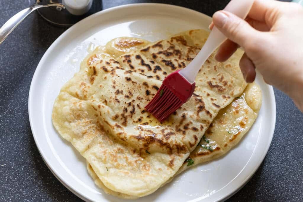 Melted butter brushing over a freshly cooked gluten free naan flatbread