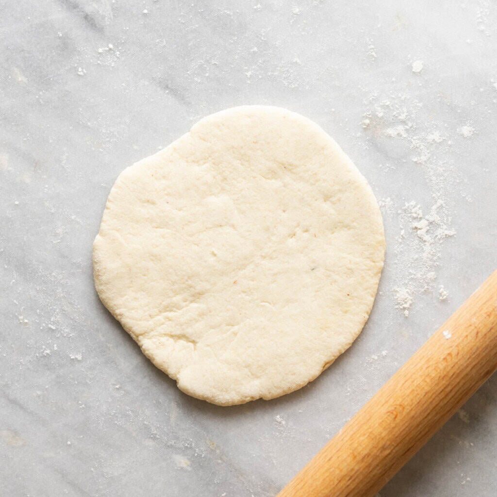 gluten free pita dough rolled out into a 6 inch circle
