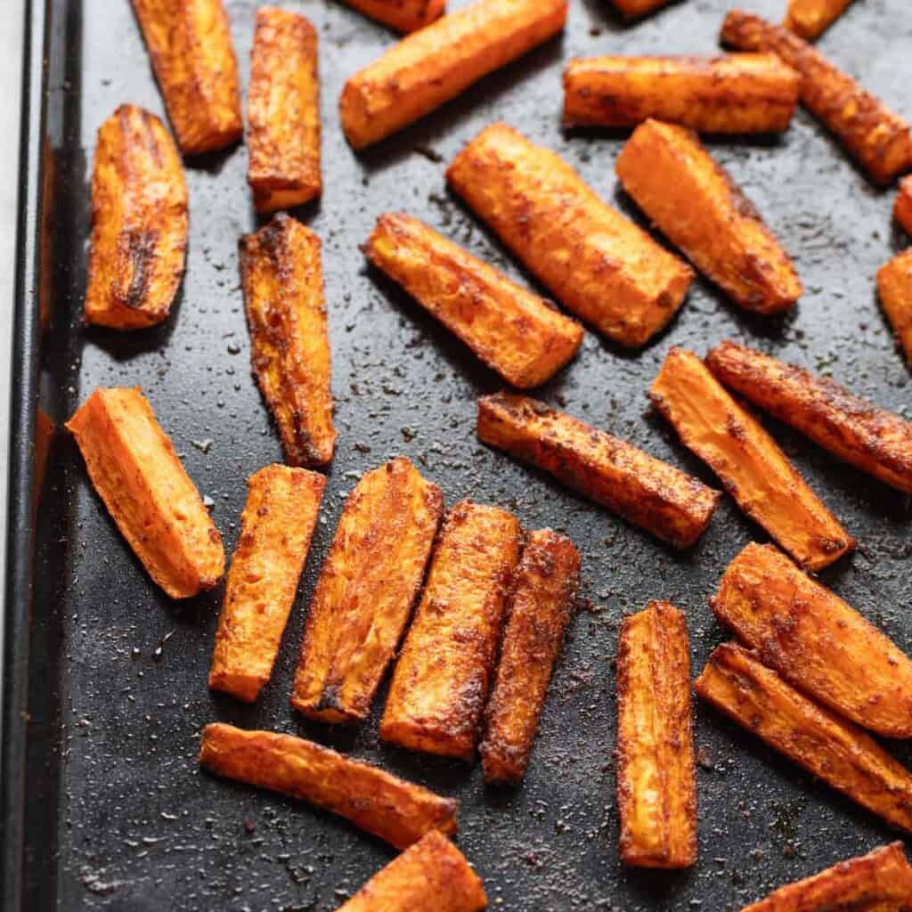 Spiced, roasted carrots sticks on a baking sheet