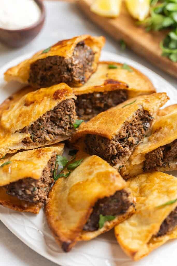 A platter of gluten free arayes showing off the meat-filled insides