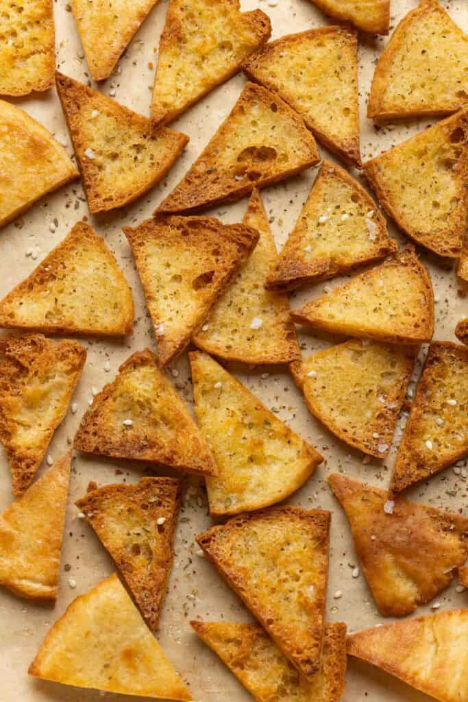 Baked homemade gluten free pita chips on a baking sheet sprinkled with za'atar spice