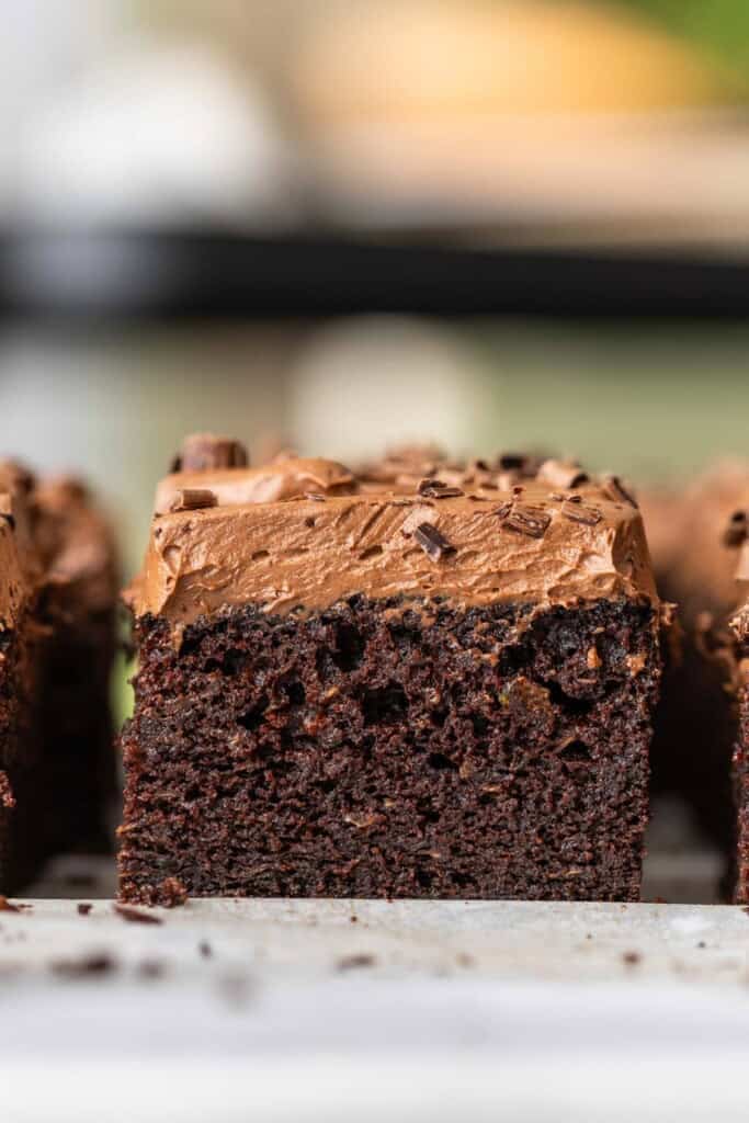 A slice of gluten free chocolate zucchini cake with chocolate buttercream frosting