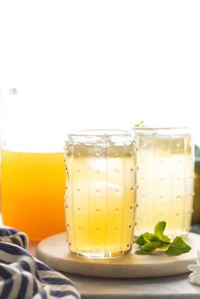 A couple of glasses of iced green tea lemonade with a fresh sprig of mint