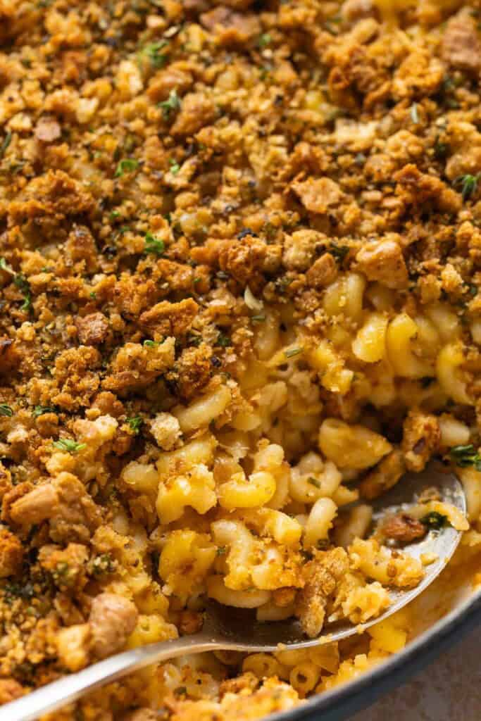 A serving spoon in a hard cider caramelized onion & bacon mac and cheese
