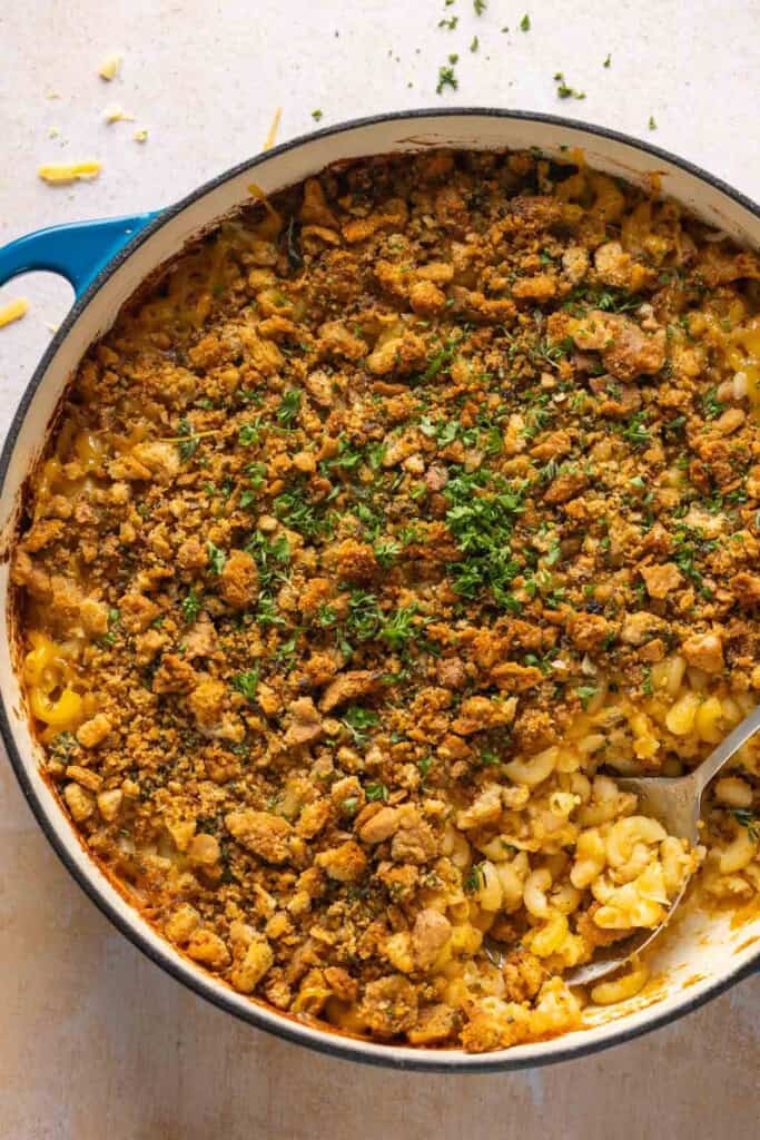 Hard cider caramelized onion & bacon mac and cheese in a casserole dish with a serving spoon inside