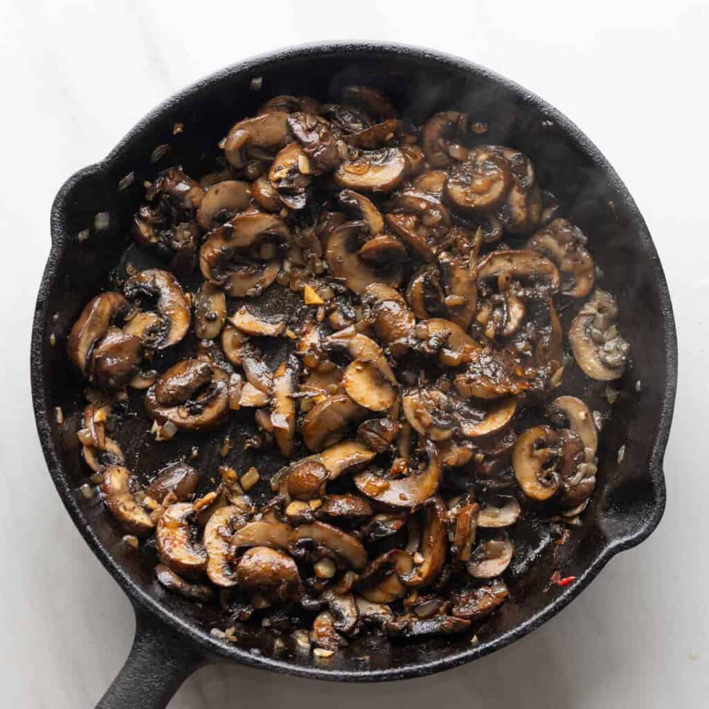 sautรฉd onions, mushrooms and garlic in a pan mixed with herbs & spices