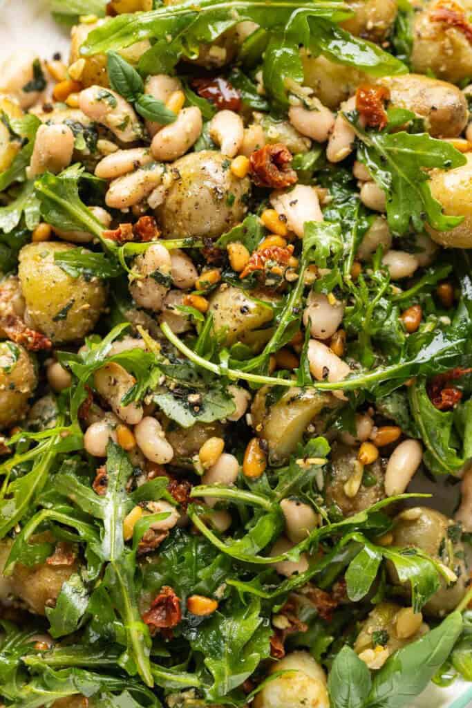 A salad made with boiled potatoes, white beans, sundried tomatoes, toasted pine nuts, rocket and pesto.
