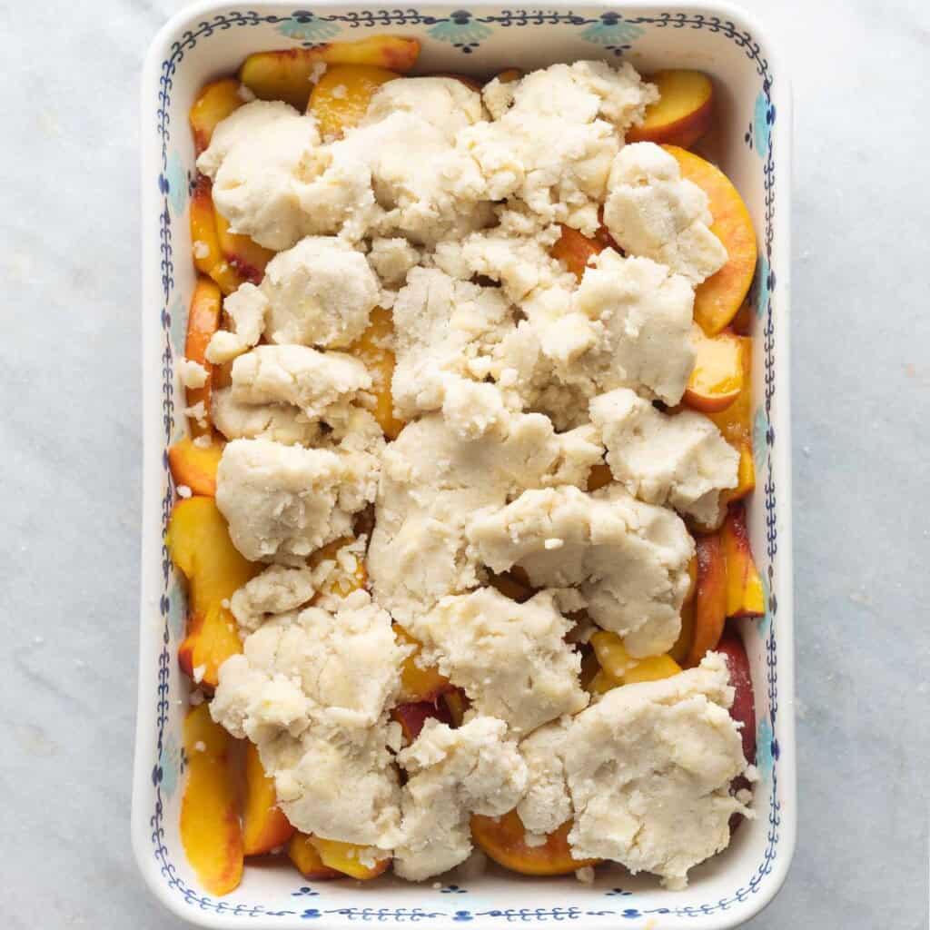 gluten free peach cobbler in an 11x7-inch baking dish before baking