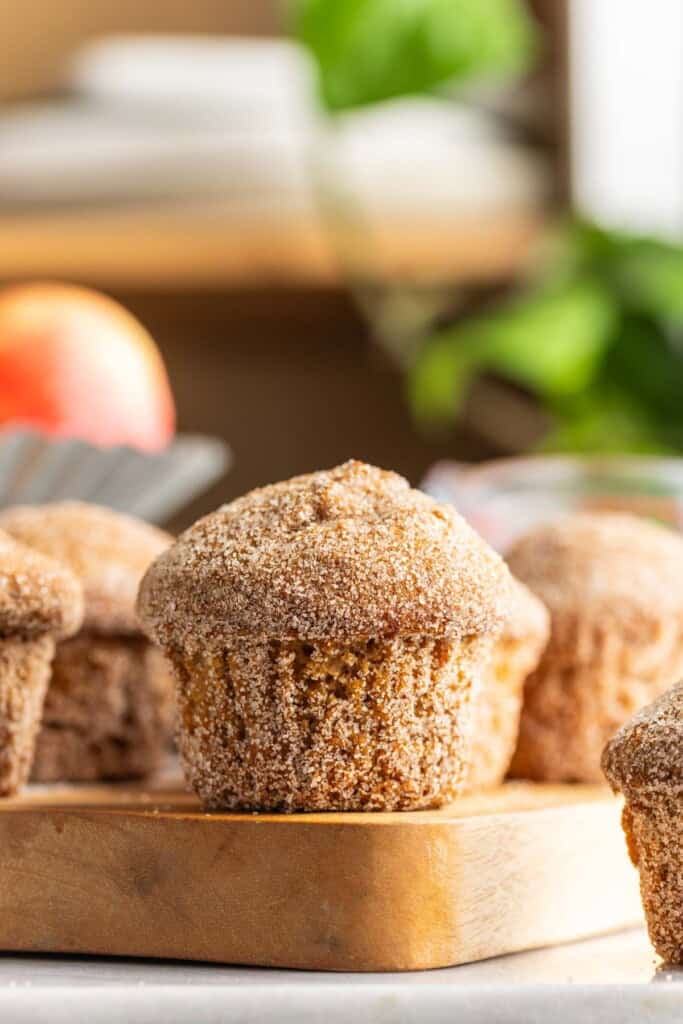 Gluten Free Apple Cider Muffins coated in a cinnamon-sugar coating on a wooden board.