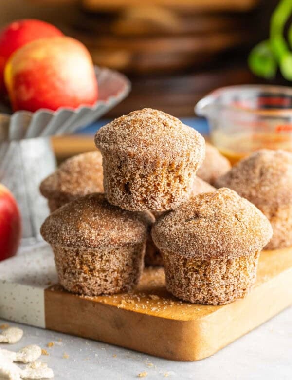 A small pyramid stack of Gluten Free Apple Cider Muffins on a wooden board.