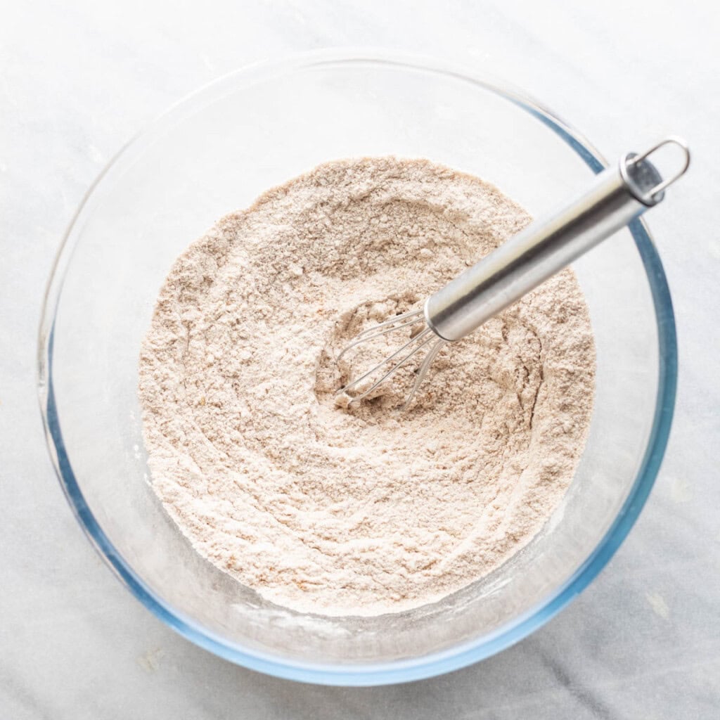 A mixing bowl of dry ingredients: flour, cinnamon, baking powder, salt, xanthan gum.