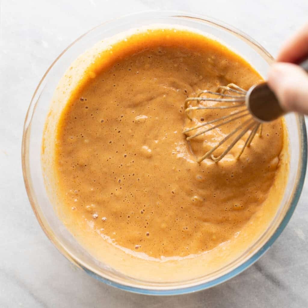 Gluten free pumpkin pancakes batter whisking in a bowl